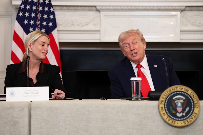 Donald Trump speaks while Attorney General Pam Bondi smiles at him while they sit at a table for the White House antifa discussion.
