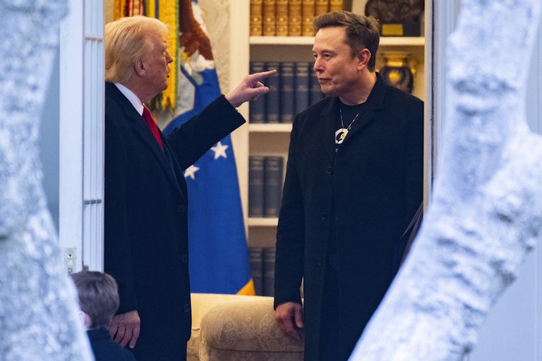 Donald Trump points at Elon Musk as they speak in the Oval Office