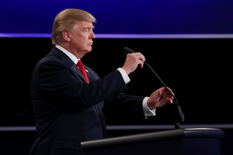 Republican presidential nominee Donald Trump adjusts the microphone during the 2016 U.S. presidential debate on October 19, 2016 in Las Vegas, Nevada.