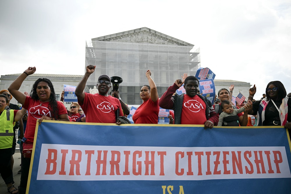 People hold a banner as they participate in a protest outside the Supreme Court over President Donald Trump’s move to end birthright citizenship.