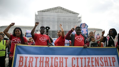People hold a banner as they participate in a protest outside the Supreme Court over President Donald Trump’s move to end birthright citizenship.