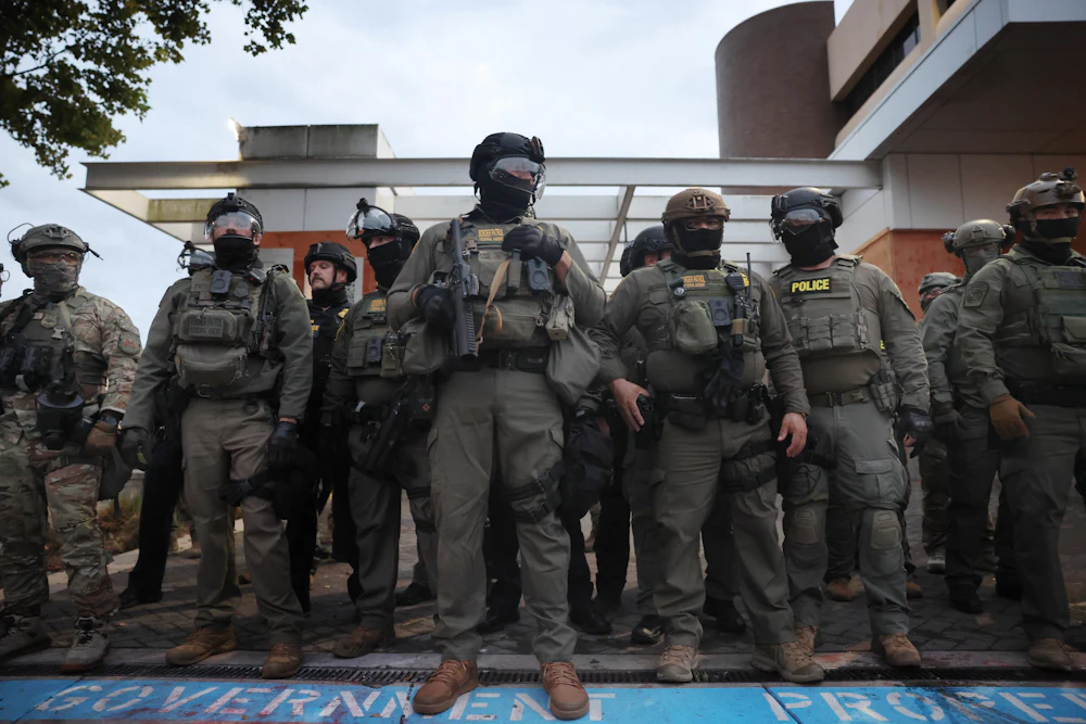 Federal agents hold back protesters outside a downtown ICE facility in Portland, Oregon.