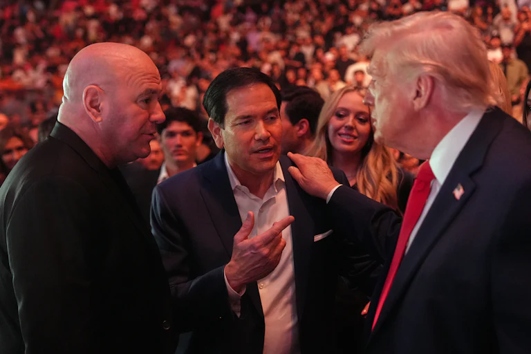 President Donald Trump speaks with Secretary of State Marco Rubio and UFC CEO Dana White while at a UFC fight. Tiffany Trump smiles in the background.