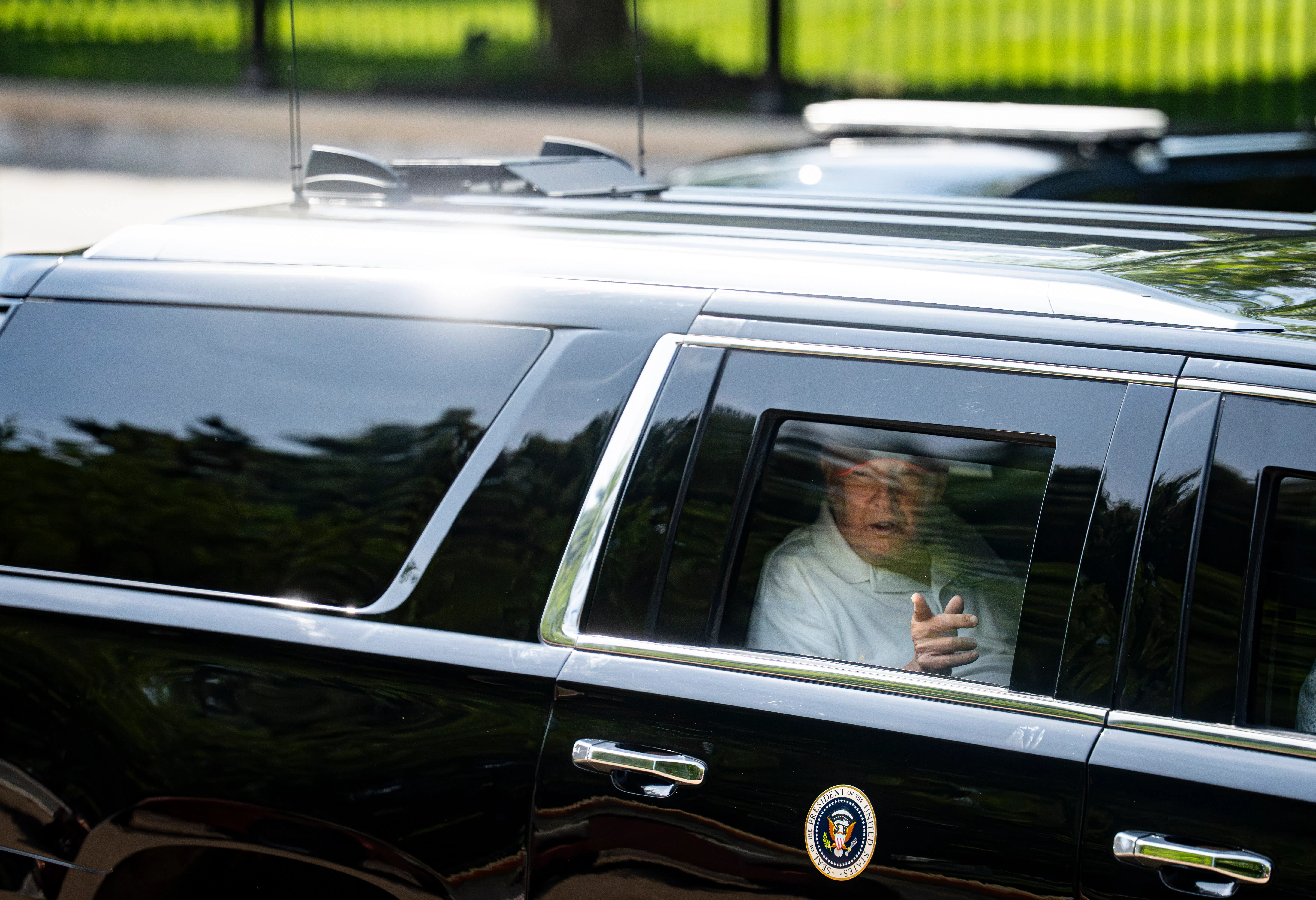 Donald Trump points out the car window as he rides in his motorcade