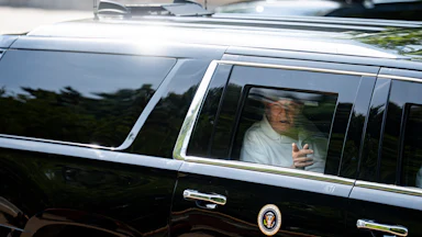 Donald Trump points out the car window as he rides in his motorcade