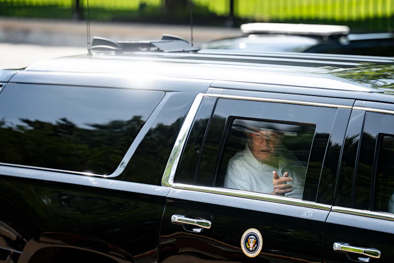 Donald Trump points out the car window as he rides in his motorcade