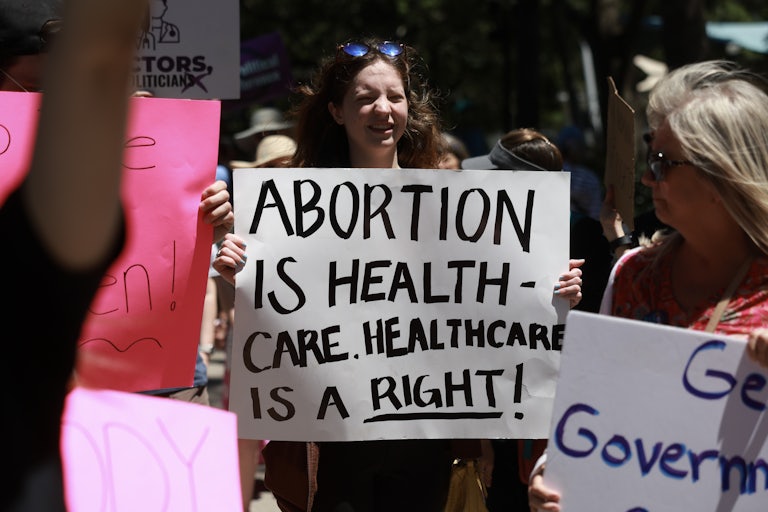 People hold protest signs