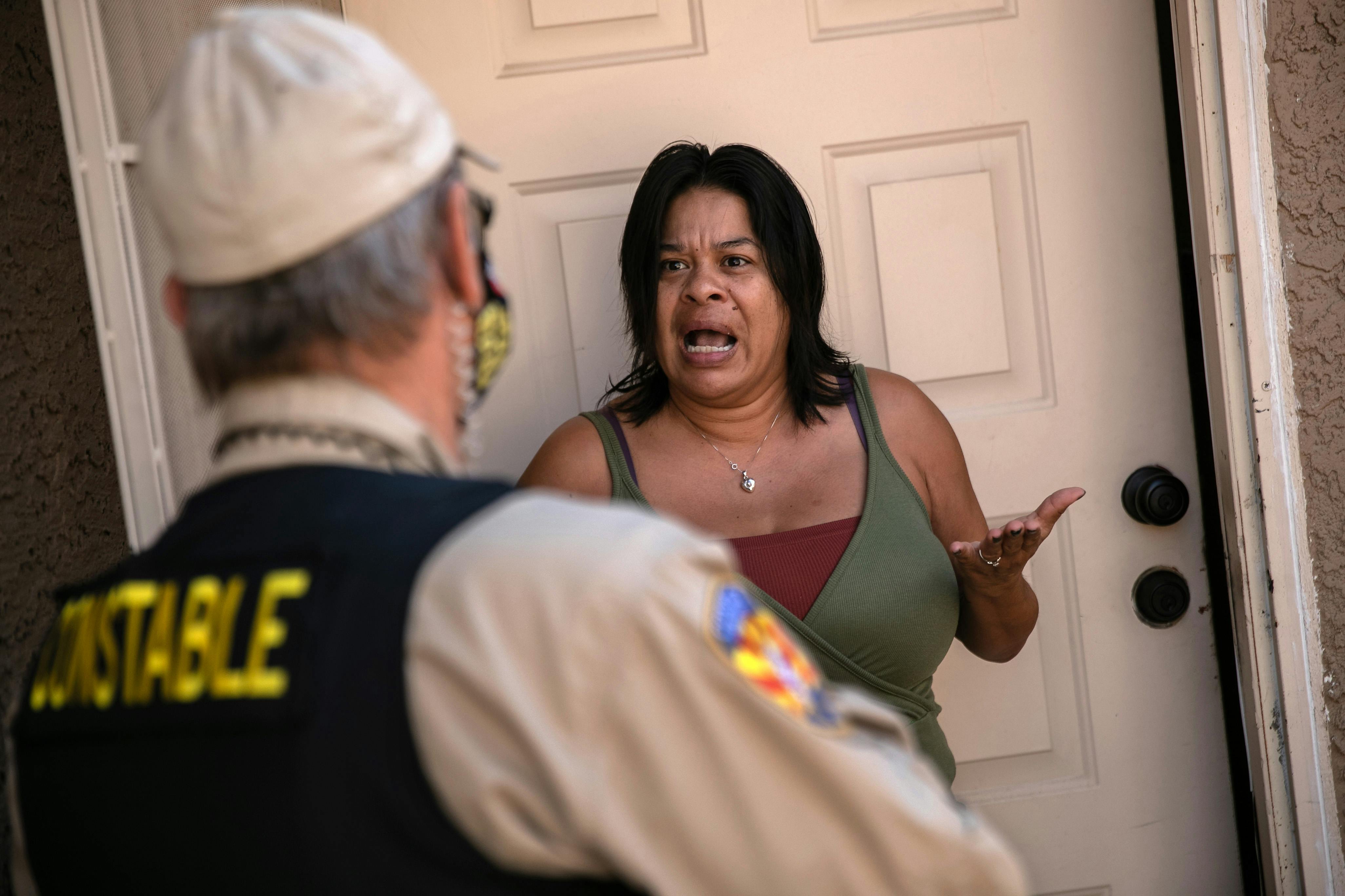 A tenant speaks with a Maricopa County constable who arrived with an eviction order