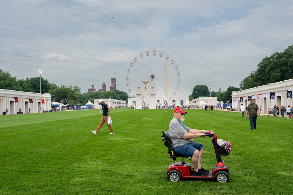 An old man on a riding scooter visits the Great American State Fair, which is very sparsely attended.