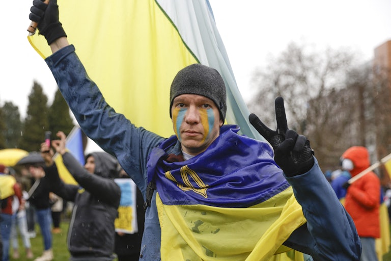 A demonstrator flashes a peace sign at a rally against the war in Ukraine in Seattle.