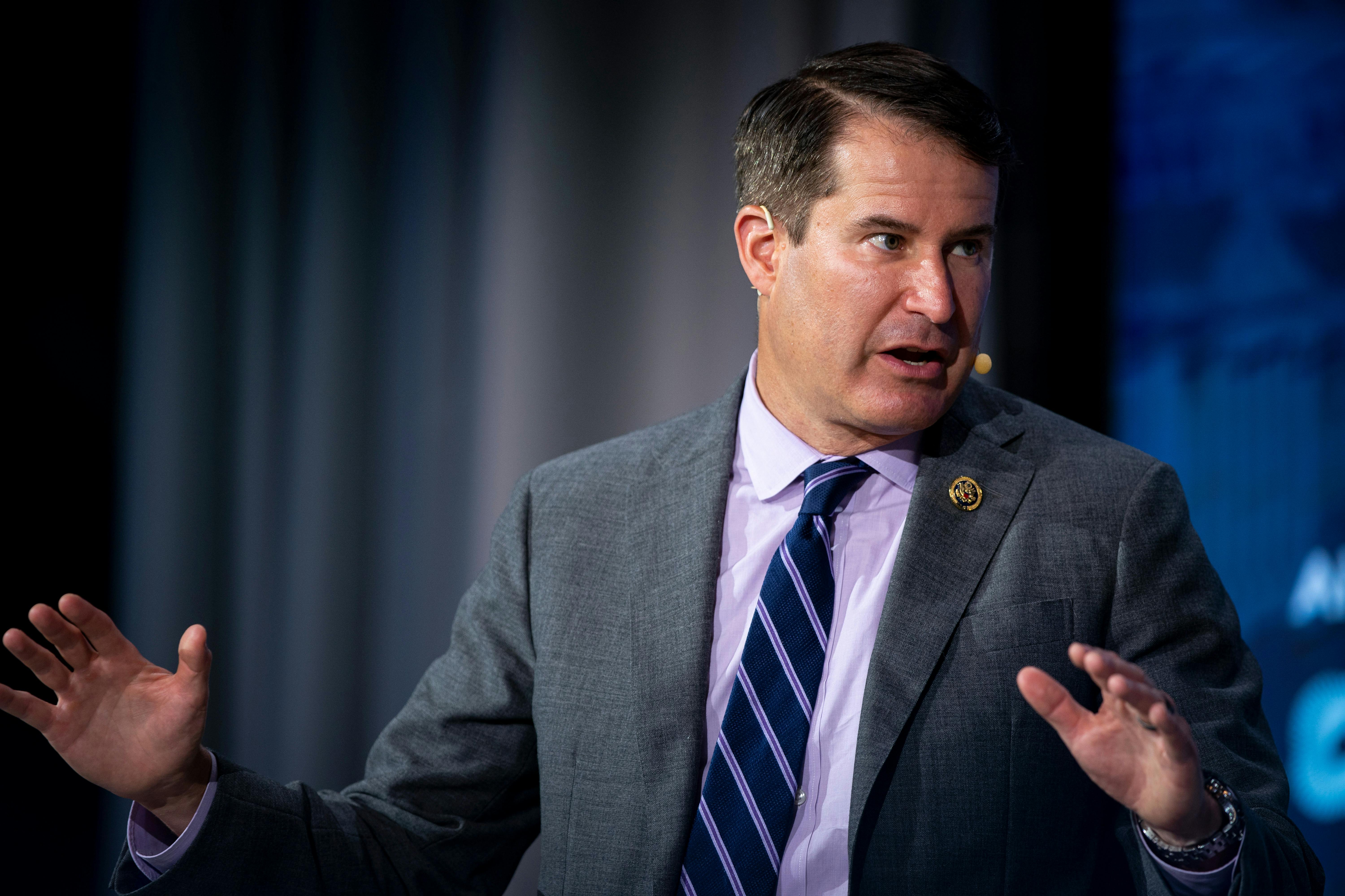 Representative Seth Moulton raises both hands as if in confusion or to make a point.