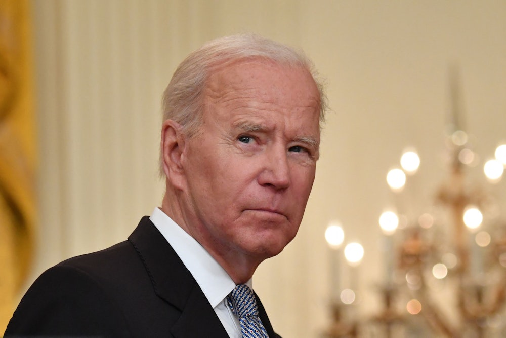 President Joe Biden glances over his right shoulder as he walks through the White House.
