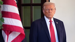 Donald Trump stands near a U.S. flag.