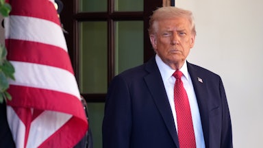 Donald Trump stands near a U.S. flag.