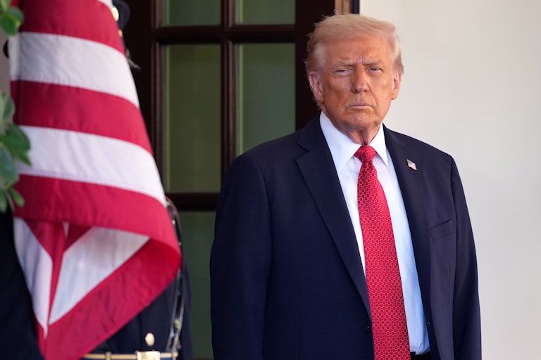 Donald Trump stands near a U.S. flag.