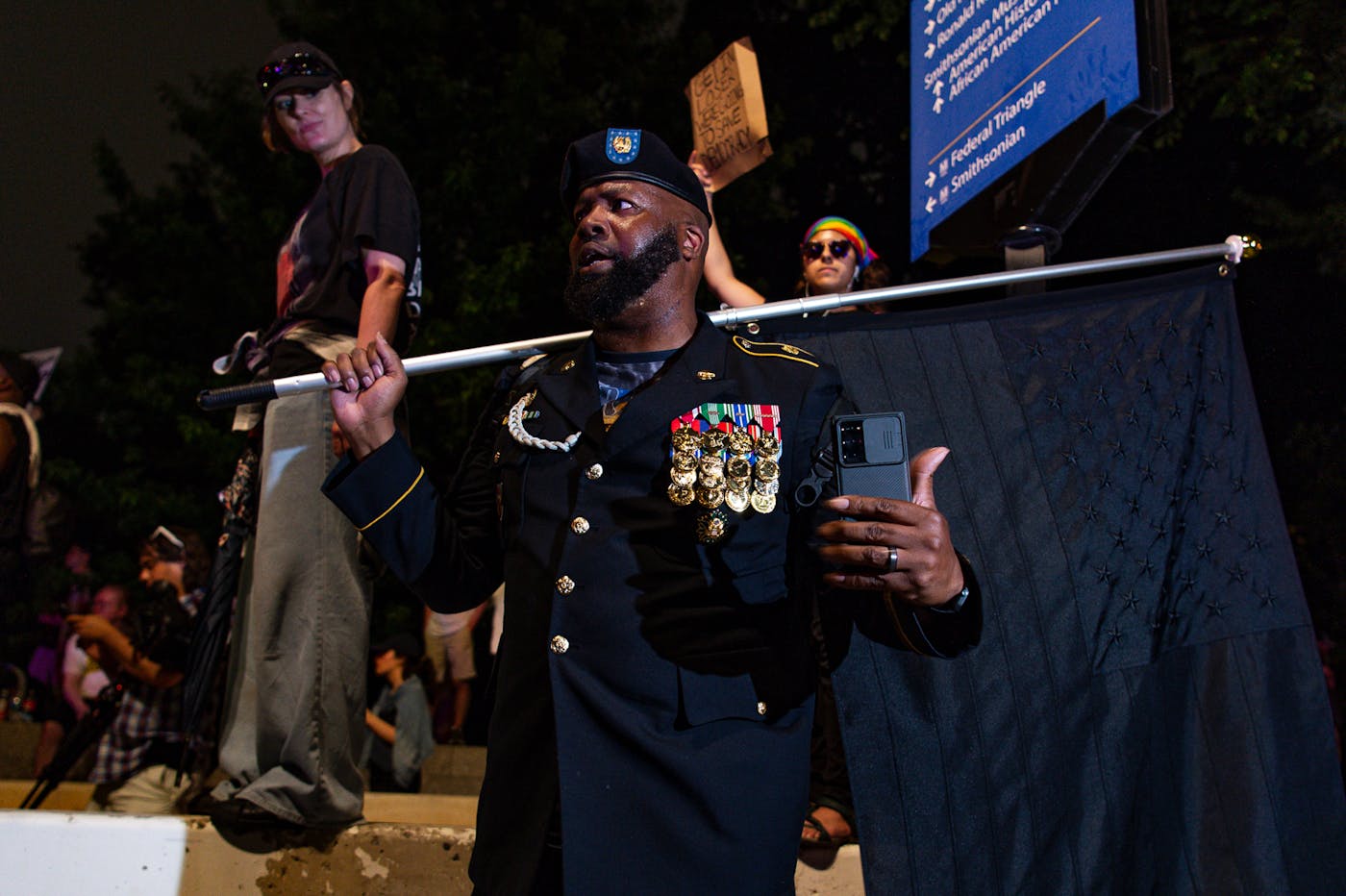 A retired Army Master Sergeant from Baltimore, Maryland, holds a black American flag, which is known to be symbol of resistance and opposition to government overreach. 