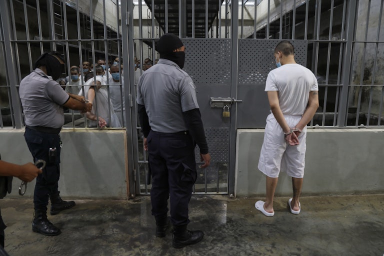 Prison officers remove handcuffs from a prisoner to enter a cell at CECOT (Center for the Compulsory Housing of Terrorism) in El Salvador.