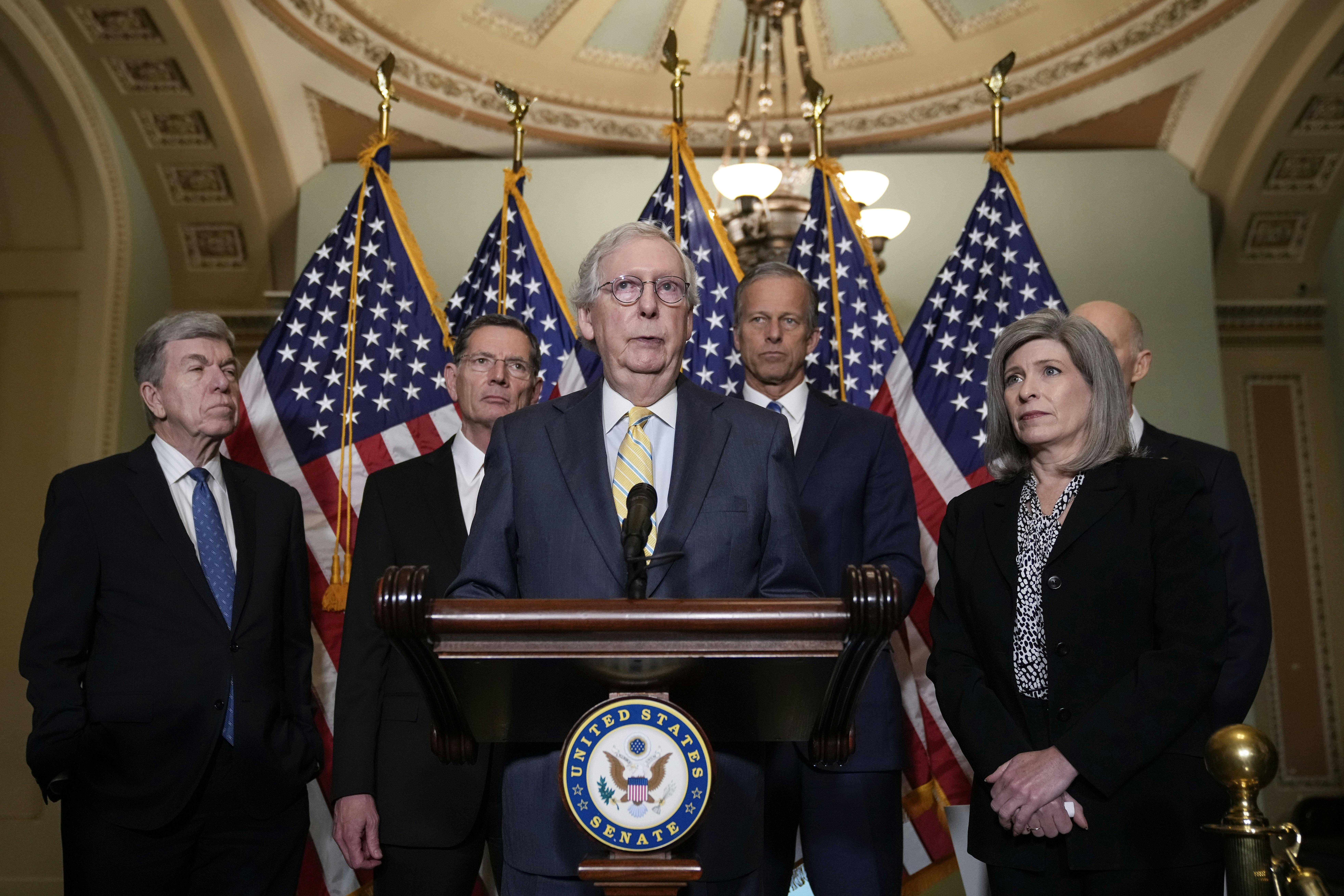 Senator Mitch McConnell stands with Senate Republican leadership behind a lectern, addressing reporters.