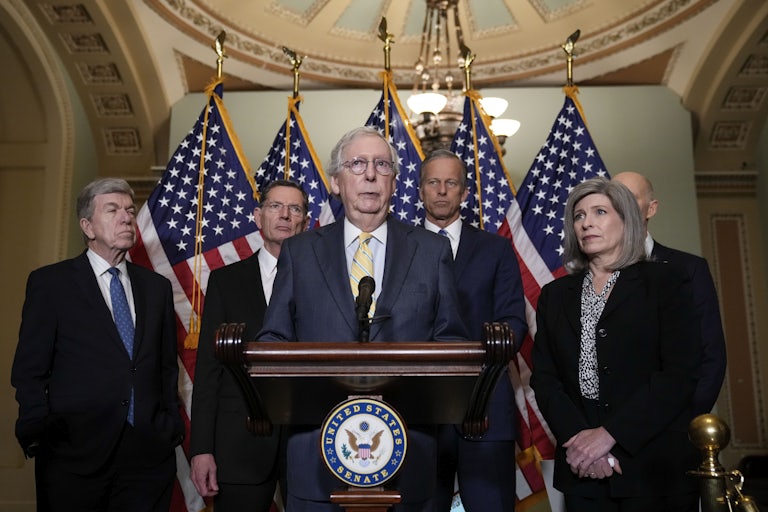 Senator Mitch McConnell stands with Senate Republican leadership behind a lectern, addressing reporters.