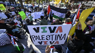 A protester holds a sign that reads "Viva Palestina Viva"