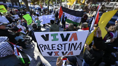 A protester holds a sign that reads "Viva Palestina Viva"