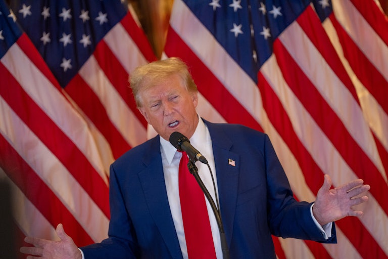 Donald Trump gestures as he speaks into a microphone