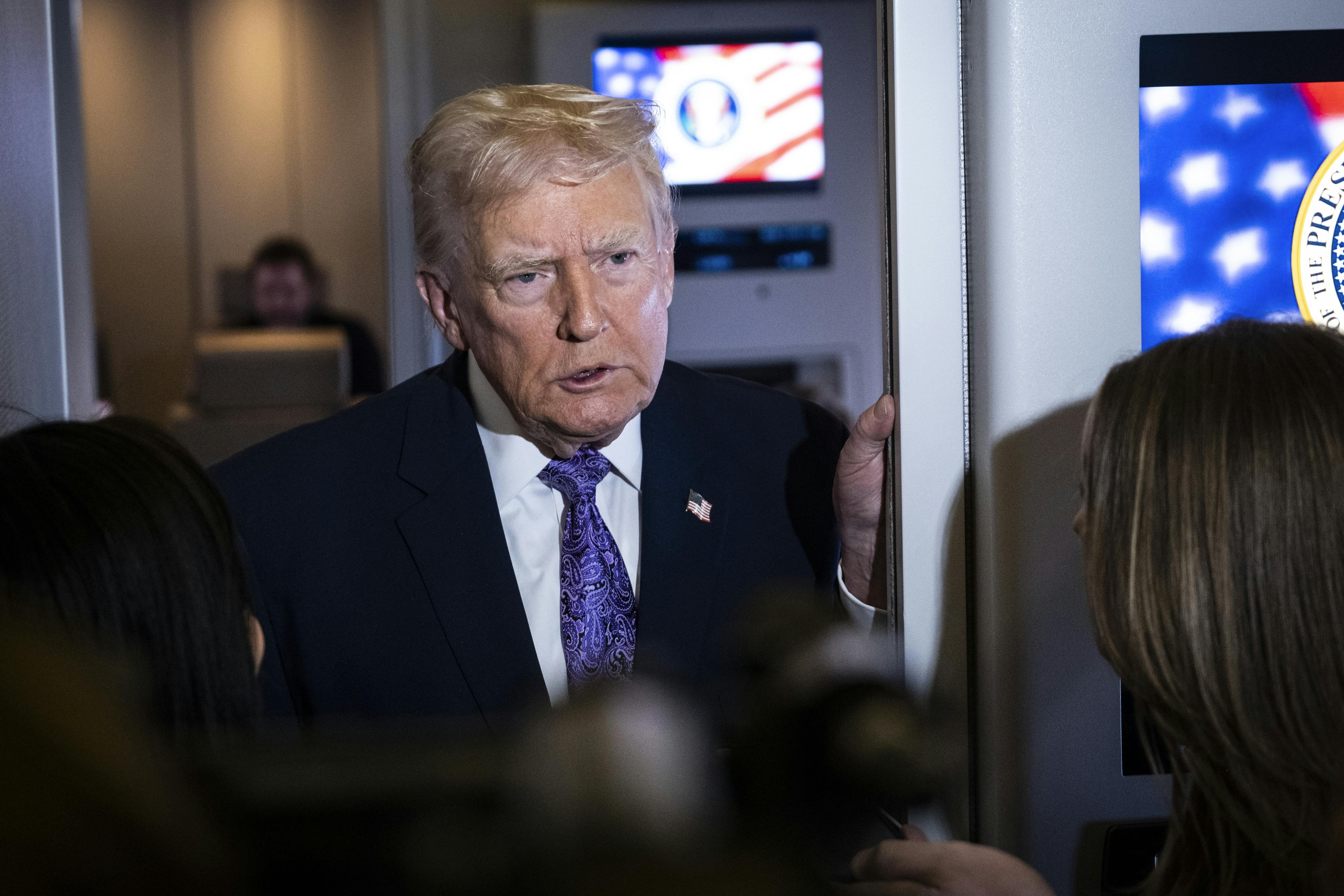 Donald Trump speaks to reporters aboard Air Force One.