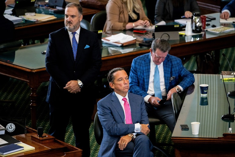 Mitch Little waits with two other men in the Texas state Capitol.