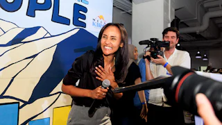 Melat Kiros smiles while holding a microphone.