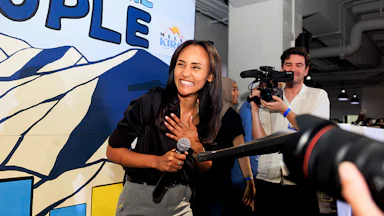 Melat Kiros smiles while holding a microphone.