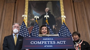 Speaker of the House Nancy Pelosi stands behind a podium labeled "America Competes Act of 2022."