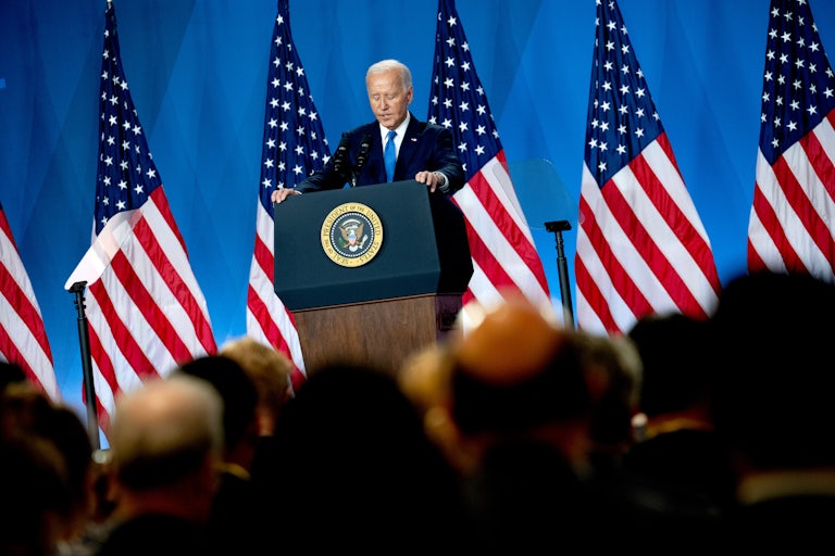 Joe Biden looks down at the podium during a press conference