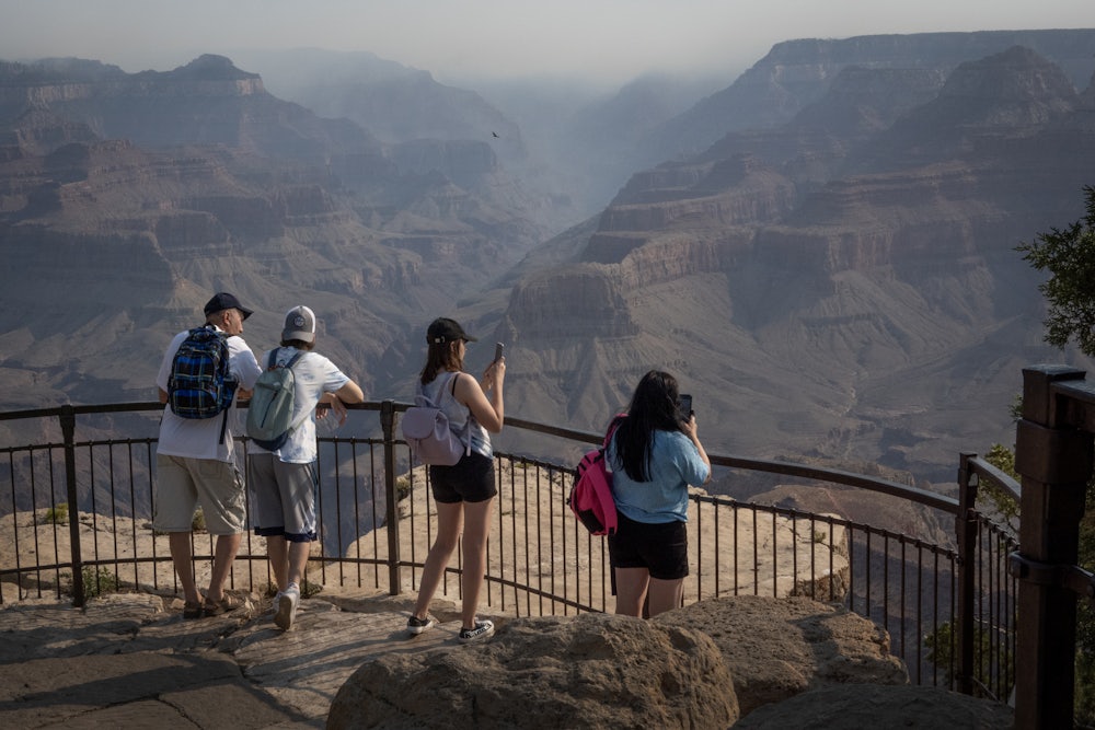 On July 15, tourists took pictures of smoke from nearby wildfires settling into the Grand Canyon. The fires burned thousands of acres and destroyed the historic Grand Canyon Lodge.