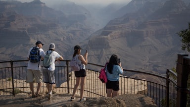On July 15, tourists took pictures of smoke from nearby wildfires settling into the Grand Canyon. The fires burned thousands of acres and destroyed the historic Grand Canyon Lodge.