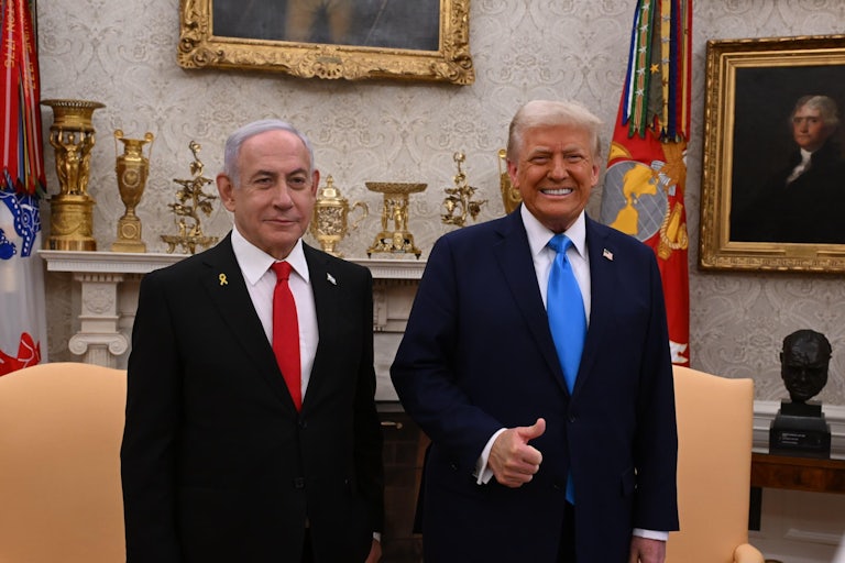 Donald Trump and Israeli Prime Miniser Benjamin Netanyahu stand in the White House. Both smile and Trump gives a thuumbs up.