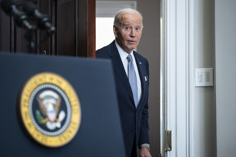 Joe Biden enters a room to give a press conference