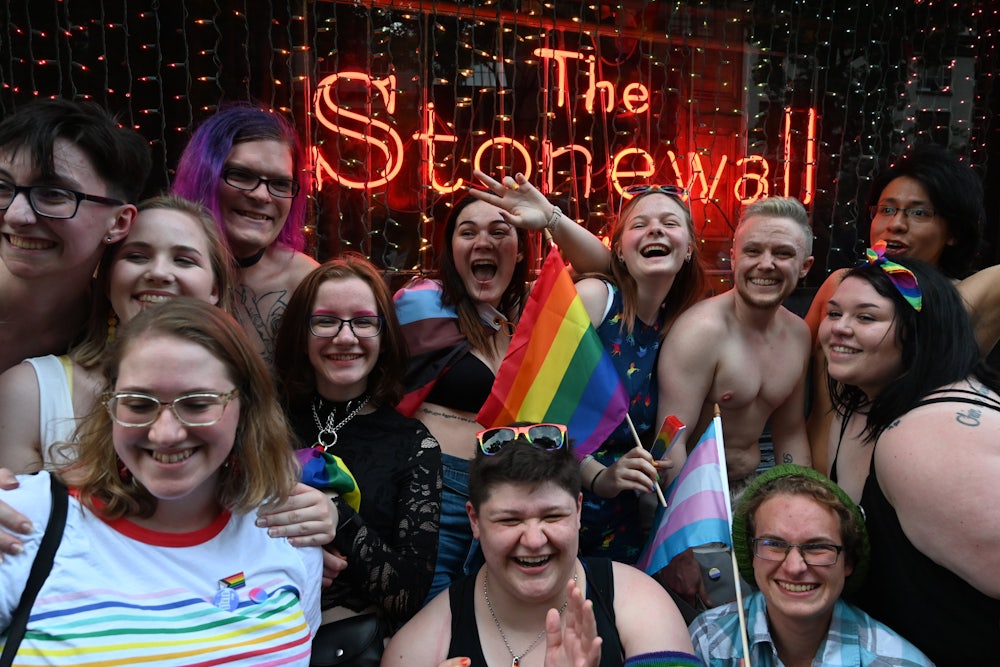 People pose in front of the Stonewall Inn in New York