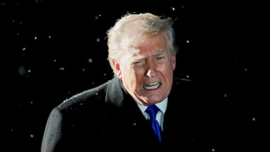 Donald Trump speaks while standing by Marine One. It is snowing.