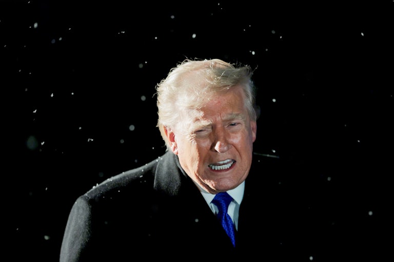 Donald Trump speaks while standing by Marine One. It is snowing.