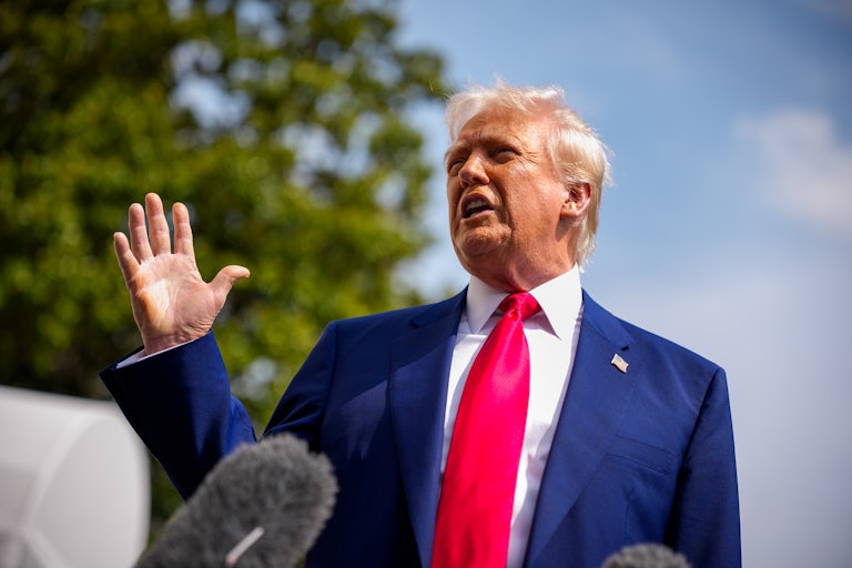 Donald Trump gestures while speaking to reporters outside the White House