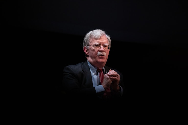 John Bolton folds his hands in front of him while speaking at Duke University