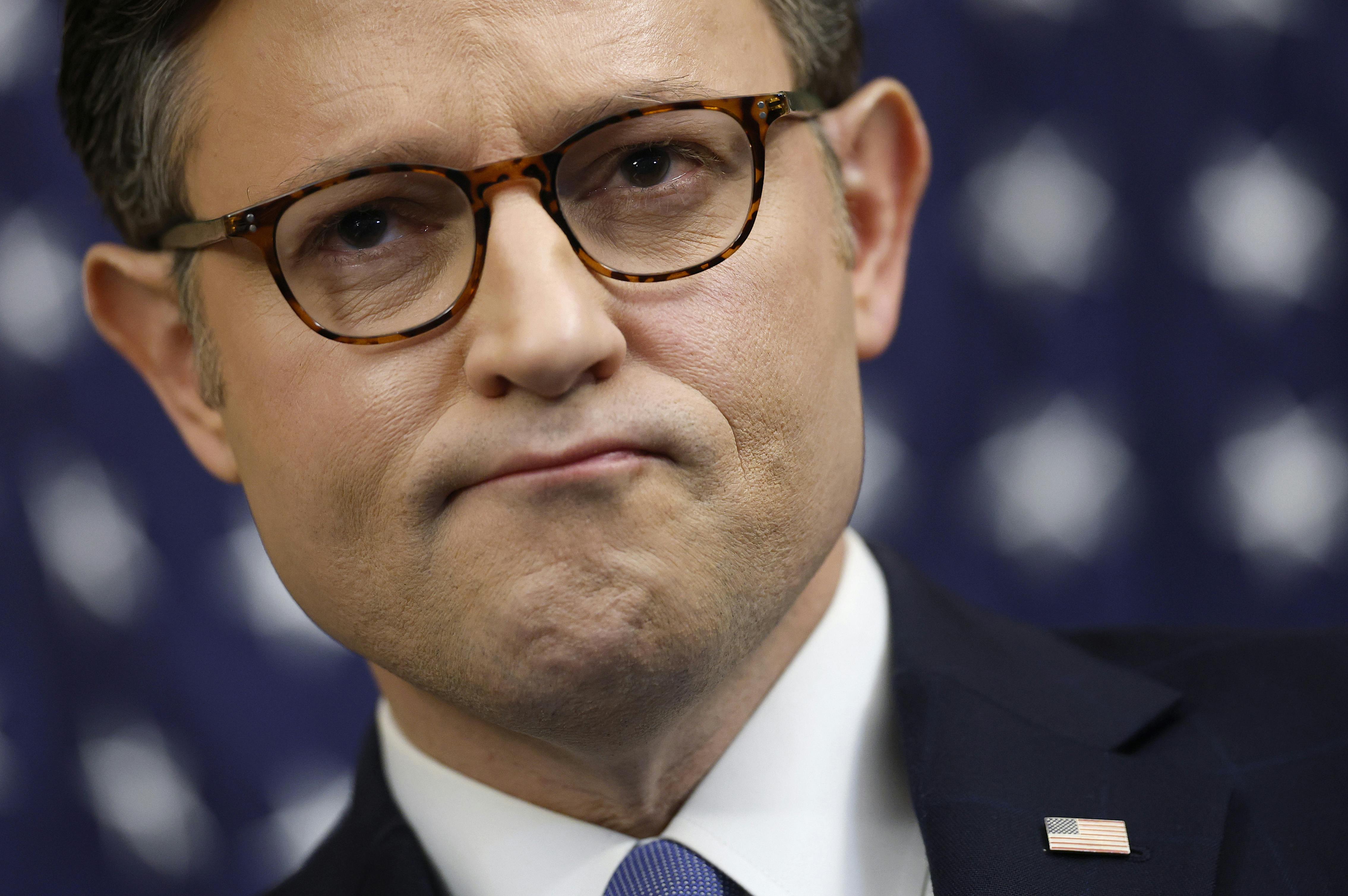 House Speaker Mike Johnson frowns during a press conference