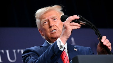 Trump grasps a microphone at a lectern.