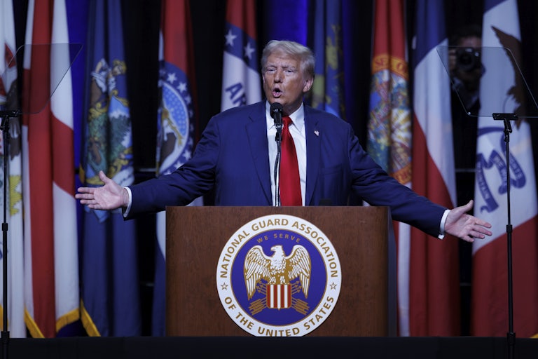 Donald Trump holds his arms out while speaking at a campaign event
