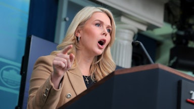 Karoline Leavitt yells at the podium in the White House press briefing room.