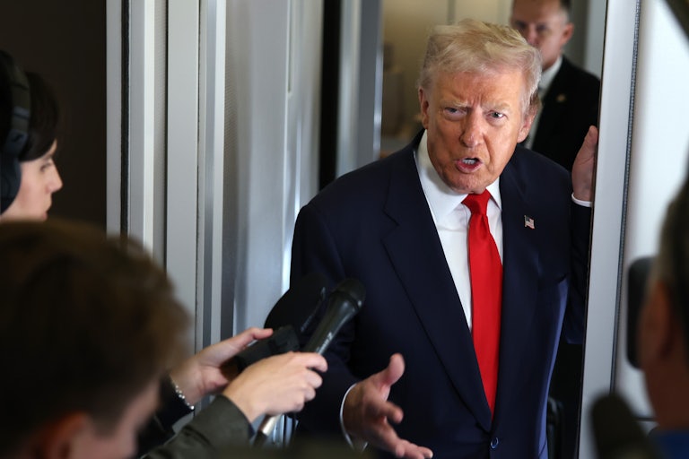 Donald Trump speaks to reporters aboard Air Force One.