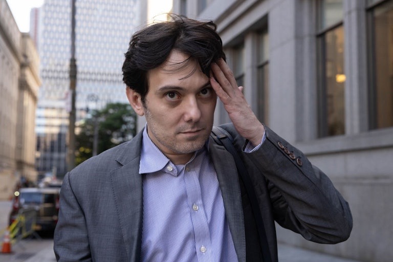 Martin Shkreli touches his forehead