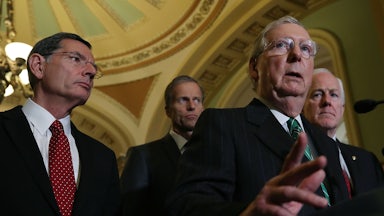 From left, John Barrasso, John Thune, and John Cornyn stand behind Mitch McConnell