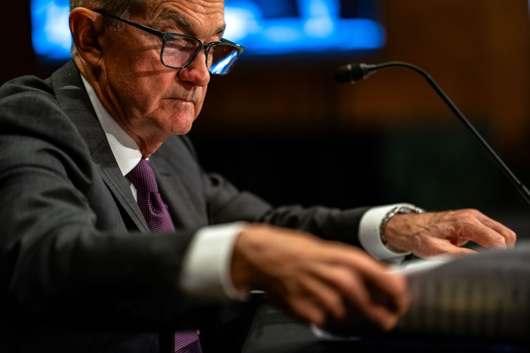 Fed Chair Jerome Powell testifies in Congress as he shuffles papers.