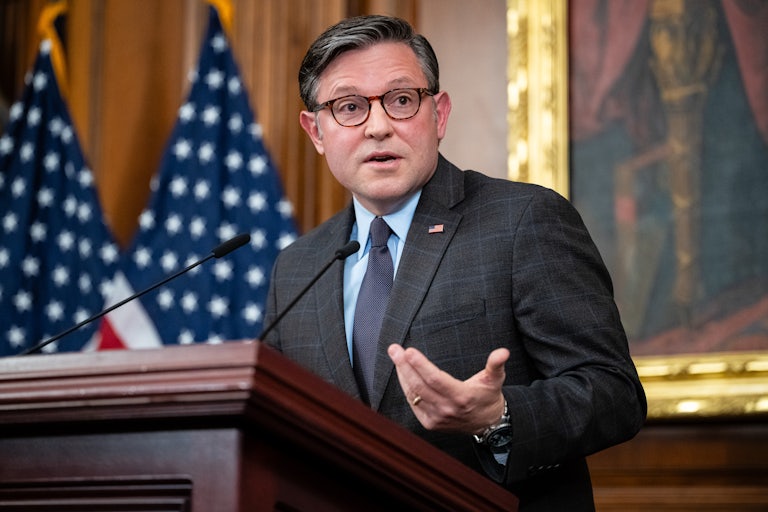 House Speaker Mike Johnson gestures while speaking at a podium